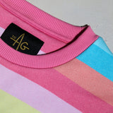 Close-up of The AG Le Candy Cloud Kids’ Sweatshirt featuring a pink ribbed crew neckline, The AG black and gold woven neck label, and pastel striped fabric in pink, blue, lilac, peach and green.
