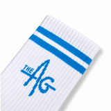 A close-up of a white ribbed sock with two blue stripes near the cuff and a blue 'THE AG' logo knitted into the side, shown on a white background.